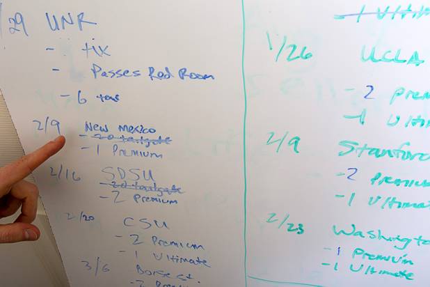Company co-founder Tom Ellinson points to a white board that shows sports packages that are still available at the Fandeavor offices in the Ogden in downtown Las Vegas, Jan. 28, 2013. Fandeavor is a sports marketing group that sells special game-day packages to fans.