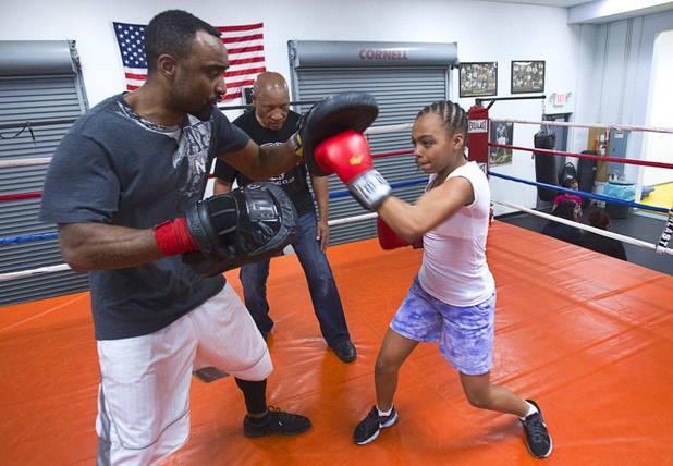 Former boxing referee Richard Steele watches as Czarina McCoy, 12, works on her timing with volunteer coach Jermaine Simpkins at the Richard Steele Boxing Club in North Las Vegas Tuesday, Jan. 29, 2013.