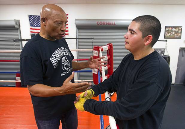 Former boxing referee Richard Steele talks with Jassiel Gutierrez, 14, at the Richard Steele Boxing Club in North Las Vegas Tuesday, Jan. 29, 2013. Steele credits the boxing club for keeping Gutierrez on the right path. "He's the first to come in and the last to leave," Steele says.