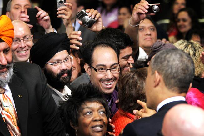 Las Vegas resident Alan Aleman, 20, shows President Barack Obama his work card after a speech about immigration reform at Del Sol High School in Las Vegas on Tuesday, January 29, 2013. Aleman, who was brought illegally to the United States by his parents when he was 11, was one of the first Las Vegas residents to get his Deferred Action for Childhood Arrivals (DACA) work permit.