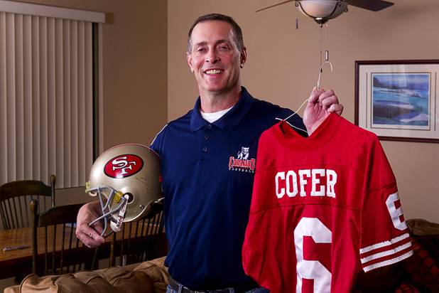 Mike Cofer, an assistant football coach at Coronado High School, poses with memorabilia at his home in Henderson, Wednesday, Jan. 30, 2013. Cofer was an NFL kicker and played with the San Francisco 49ers during Super Bowl wins in 1989 and 1990.