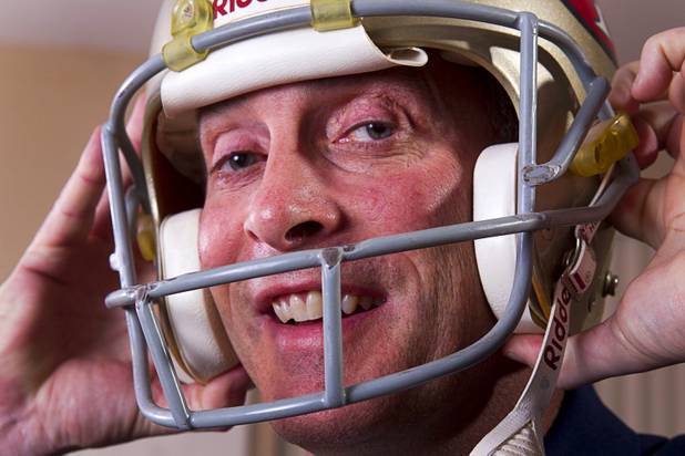 Mike Cofer, an assistant football coach at Coronado High School, tries on his San Francisco 49ers helmet at his home in Henderson Wednesday, Jan. 30, 2013. Cofer was a NFL kicker and played with the San Francisco 49ers during Super Bowl wins in 1989 and 1990.