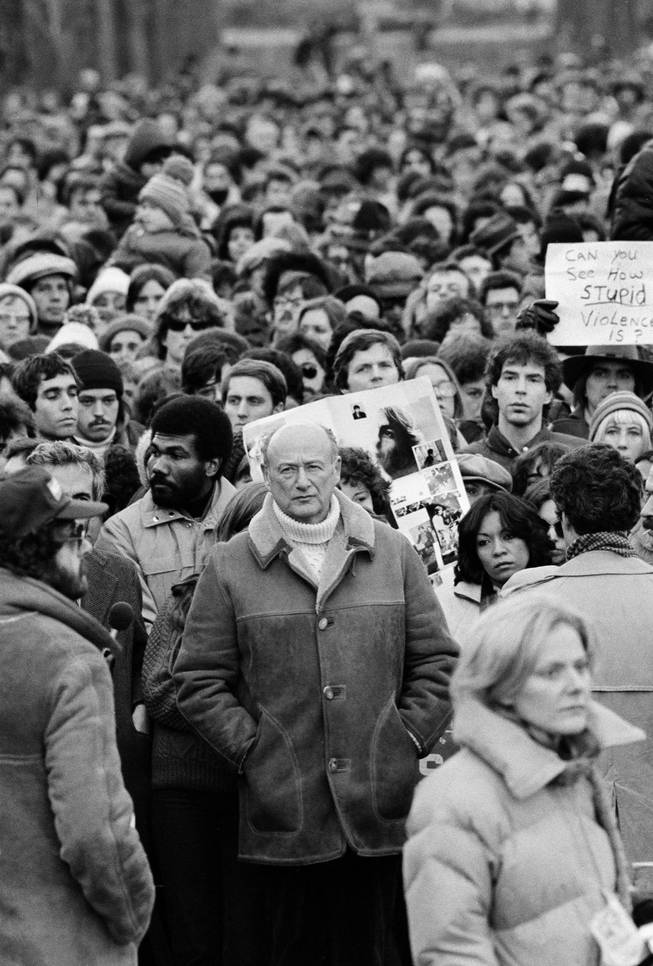 In this Dec. 14, 1980, file photo, New York Mayor Ed Koch stands among Beatles' fans paying tribute to the late John Lennon during a silent vigil that was called by Mayor Koch in New York's Central Park. 