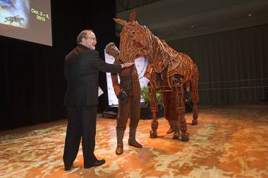 Myron Martin, president and CEO of The Smith Center for the Performing Arts, feeds a sugar cube to Joey, the puppet horse from “War Horse,” during a donors reception at The Smith Center for the Performing Arts on Monday, Feb. 4, 2013. “War Horse” is at The Smith Center from Oct. 2-6.