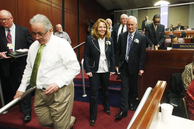 Assemblywoman Marilyn Kirkpatrick heads back to her desk after shooing members of the media away from Assemblyman Steven Brooks on the first day of the 2013 legislative session Monday, Feb. 4, 2013 in Carson City.