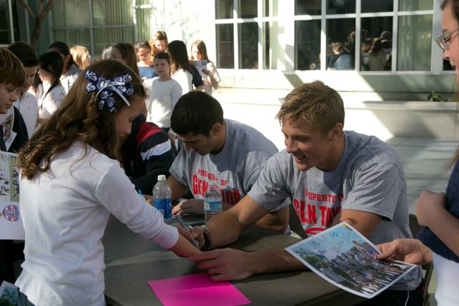 Colin Hawley of the USA Eagels Rugby Team signs the arm of a student at Glen Taylor Elementary School, Tuesday Feb. 5, 2013.