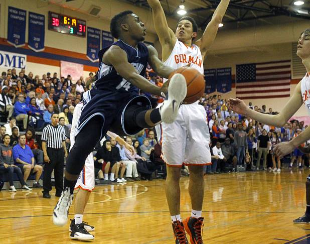 Centennial High School's Khalil Thompson, left, passes the ball during a game against Bishop Gorman at Bishop Gorman Thursday, Feb. 7, 2013. Bishop Gorman beat Centennial 79-71 in double overtime.