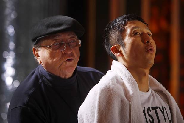 Chinese light flyweight boxer Zou Shiming (R) takes a breather during a workout in a training facility at the Palazzo in Las Vegas, Nevada February 8, 2013. Assistant Miguel Diaz is at left. Zou, a two-time Olympic gold medalist and three-time world amateur champion, will make his professional debut April 6 at the Venetian Macao Resort in Macau.