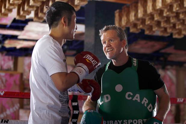Trainer Freddie Roach (R) works with Chinese light flyweight boxer Zou Shiming before a workout in a training facility at the Palazzo in Las Vegas, Nevada February 8, 2013. Zou, a two-time Olympic gold medalist and three-time world amateur champion, will make his professional debut April 6 at the Venetian Macao Resort in Macau.