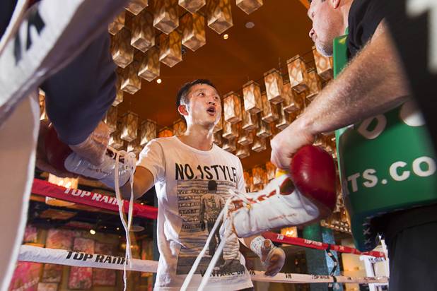 Chinese light flyweight boxer Zou Shiming (C) talks with trainer Freddie Roach (R) in a training facility at the Palazzo in Las Vegas, Nevada February 8, 2013. Zou, a two-time Olympic gold medalist and three-time world amateur champion, will make his professional debut April 6 at the Venetian Macao Resort in Macau.