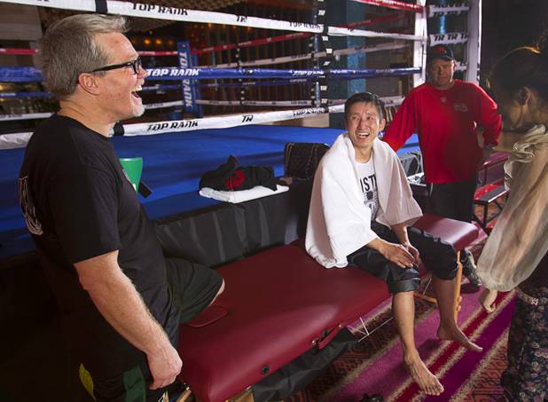 Trainer Freddie Roach and Chinese light flyweight boxer Zou Shiming laugh after a workout in a training facility at the Palazzo in Las Vegas, Nevada February 8, 2013. Zou, a two-time Olympic gold medalist and three-time world amateur champion, will make his professional debut April 6 at the Venetian Macao Resort in Macau.