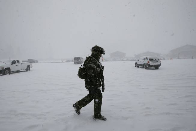A San Bernardino County Sheriff's officer walks through the command post in Big Bear Lake, Calif., Friday, Feb. 8, 2013. Police spent all night searching the snowy mountains of Southern California but were unable to find Christopher Dorner, the former Los Angeles police officer accused of carrying out a killing spree because he felt he was unfairly fired from his job.