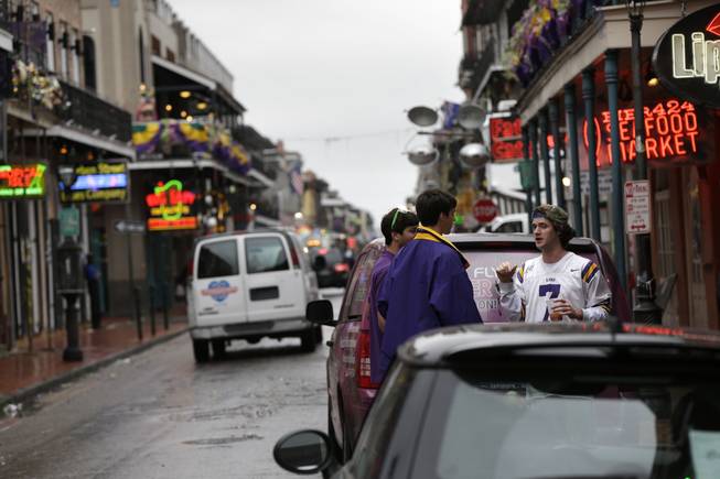 People walk near the 400 block of Bourbon Street in the French Quarter in New Orleans on Sunday, Feb. 10, 2013. 