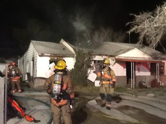 Firefighters work to extinguish an early-morning fire Sunday at a vacant downtown home.