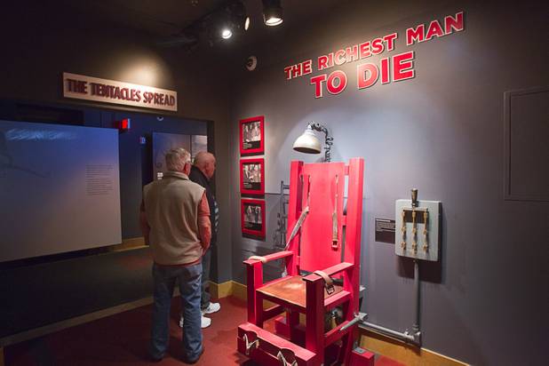 Guests look over an exhibit featuring a replica of the electric chair from Sing Sing prison at the Mob Museum, the National Museum of Organized Crime and Law Enforcement, in downtown Las Vegas Wednesday, Feb.13, 2013. The museum celebrates it's first anniversary on Valentine's Day.