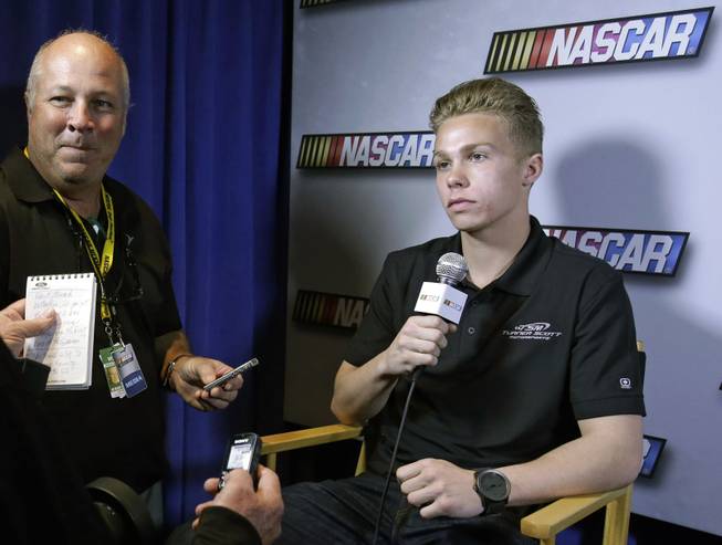 In this Feb. 14, 2013, auto racing driver Dylan Kwasniewski talks with reporters during NASCAR media day at Daytona International Speedway in Daytona Beach, Fla. Kwasniewski, the youngest driver to ever win the K&N Pro Series West championship, is into action sports, music and everything else that grabs the attention of a typical high school kid. Seizing on opportunity to introduce him to a wider audience and possibly attract a younger demographic, NASCAR co-produced a documentary series on his life on and off the track. The 10 unscripted episodes of "FLAT OUT" debuted Tuesday, Sept. 17, 2013, as part of the AOL ON original programming lineup.  
