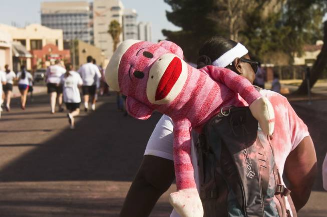 A red striped sock monkey hangs out of a participants backpack at the 5K Color Run, Saturday, Feb. 16, 2013. 