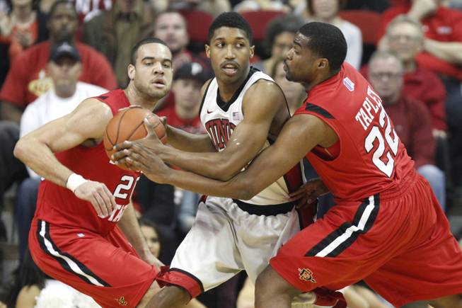 UNLV guard Justin Hawkins is defended by  San Diego State J.J. O'Brien, left, and Chase Tapley during their Mountain West Conference game Saturday, Feb. 16, 2013 at the Thomas & Mack.