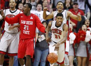 UNLV forward Khem Birch celebrates as guard Justin Hawkins takes the ball while San Diego State guard Jamaal Franklin reacts to being called for travelling during San Diego Stat'e final possession Saturday, Feb. 16, 2013 at the Thomas & Mack. UNLV won the game 72-70.