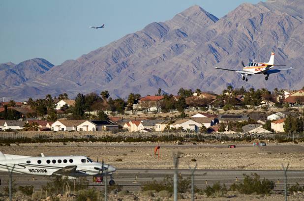 A small plane, right, comes in for a landing at the Henderson Executive Airport Monday, Feb.18, 2013.