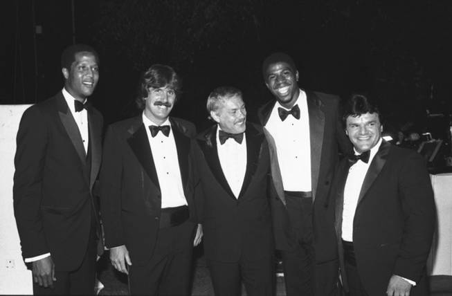 In this June 18, 1980 file photo, Jerry Buss, center, poses with players from his teams at a charity event in Beverly Hills, Calif. From left are Los Angeles Lakers' Jamaal Wilkes, Los Angeles Kings' Charlie Simmer, Buss, Lakers' Magic Johnson and Kings' Marcel Dionne. 
