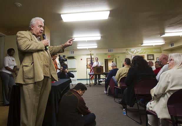 Edward Smith, left, speaks to members in the audience as well as Congressman Joe Heck, center, (R-NV) during a town hall meeting at Pacific Pines Senior Apartments in Henderson Tuesday, Feb.19, 2013.