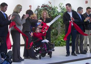 Student Madison Peck, center, helps cut a ribbon during an official opening ceremony at the new John F. Miller School, a school which serves students with disabilities and special needs, Wednesday Feb. 20, 2013. The school has been nominated for a national design award.