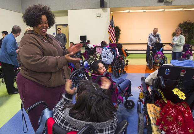 Christine Poole, a specialized teacher's assistant applauds with a student during an official opening ceremony at the new John F. Miller School, a school which serves students with disabilities and special needs, Wednesday Feb. 20, 2013. The school has been nominated for a national design award.