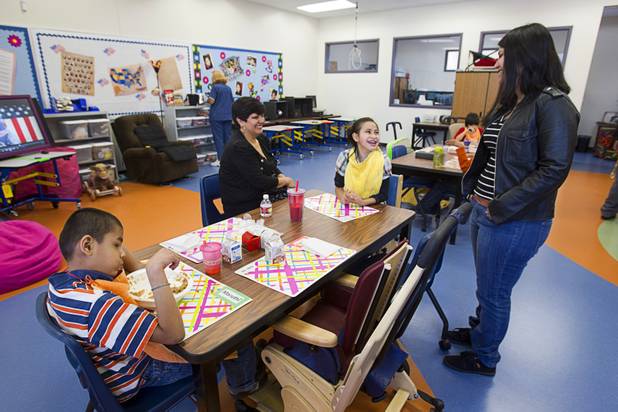 Student Dayana Segura, center, is joined by her mother and sister in a classroom following an official opening ceremony at the new John F. Miller School, a school which serves students with disabilities and special needs, Wednesday Feb. 20, 2013. The school has been nominated for a national design award.