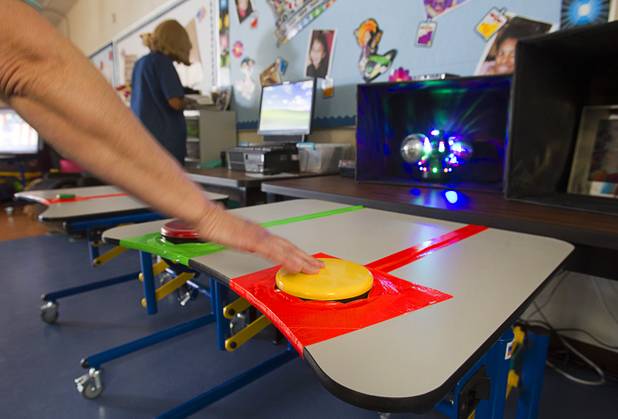 A specialized teacher's assistant demonstrates learning tools operated with pressure pads in a classroom at the new John F. Miller School, a school which serves students with disabilities and special needs, Wednesday Feb. 20, 2013. The school has been nominated for a national design award.
