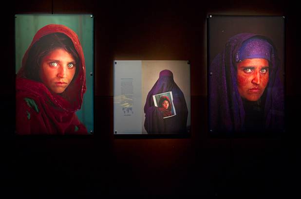 A 1984 photo of an Afghan refugee school girl taken by photographer Steve McCurry, left, and the same woman 17 years later, also by McCurry, are displayed  the 50 Greatest Photographs of National Geographic, an exhibit of National Geographics most iconic photos, at the Imagine Exhibitions Gallery in the Venetian Wednesday Feb. 20, 2013.