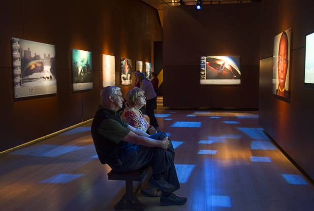 Ross and Linda Beatson of Canada watch a video at the the 50 Greatest Photographs of National Geographic, an exhibit of National Geographics most iconic photos, at the Imagine Exhibitions Gallery in the Venetian Wednesday Feb. 20, 2013.