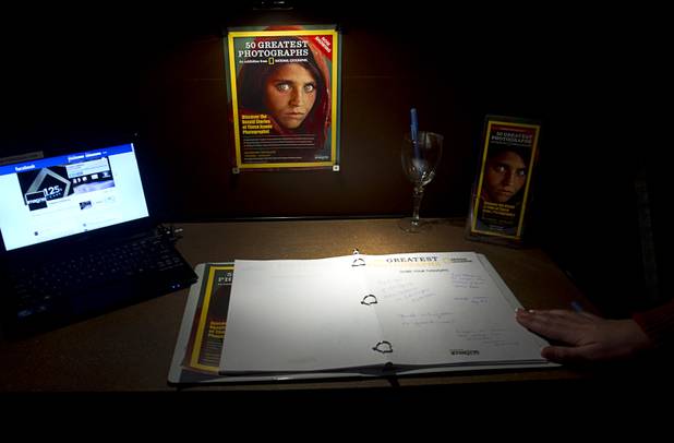 A guest book with reactions to the show is shown at the Imagine Exhibitions Gallery in the Venetian Wednesday Feb. 20, 2013. A magazine cover with a photo of an Afghan refugee school girl taken by photographer Steve McCurry is also displayed.The gallery is showing the 50 Greatest Photographs of National Geographic, an exhibit of National Geographics most iconic photos.