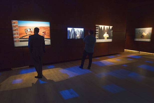 Visitors look over photos at the 50 Greatest Photographs of National Geographic, an exhibit of National Geographics most iconic photos, at the Imagine Exhibitions Gallery in the Venetian Wednesday Feb. 20, 2013. At left is a 2008 photo by Amy Toensing documenting a drought in Australia. STEVE MARCUS