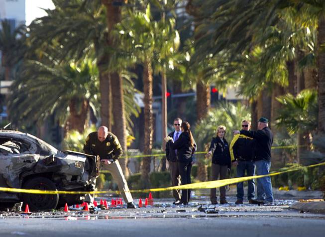 Officials investigate the site of a shooting and multi-car accident that left three people dead and at least three injured on the Las Vegas Strip early Thursday, Feb. 21, 2013.