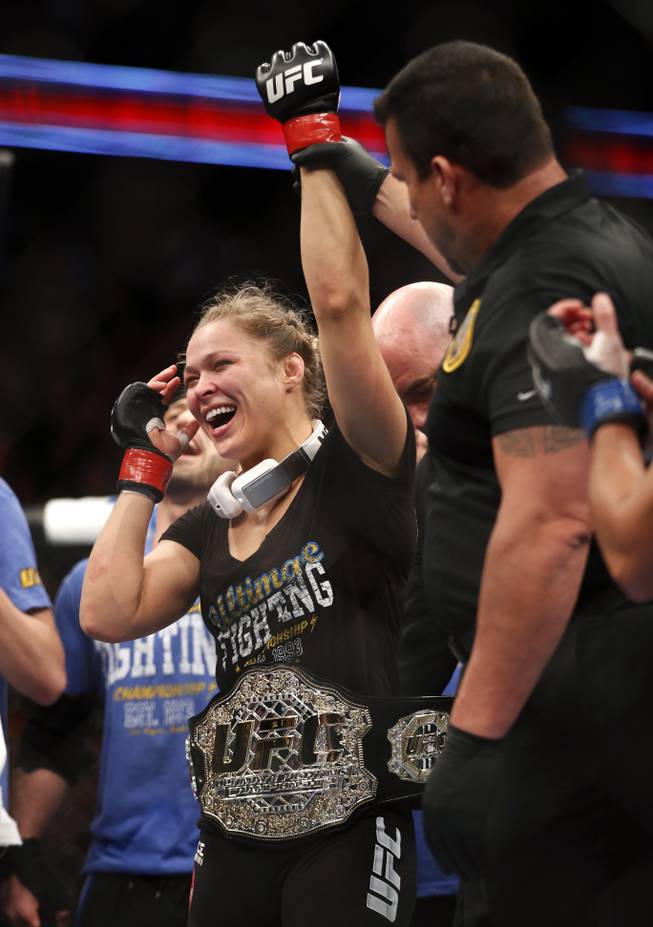 Ronda Rousey celebrates her win against Liz Carmouche after their UFC 157 women's bantamweight championship mixed martial arts match in Anaheim, Calif., Saturday, Feb. 23, 2013. Rousey won the first womens bout in UFC history, forcing Carmouche to tap out in the first round. (AP Photo/Jae C. Hong)