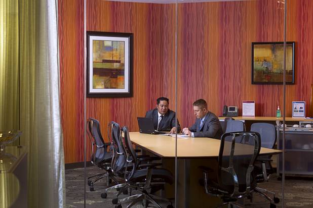 Executive suites managers Leo Agustin, left, and Michael Hatcher work in a glassed conference room at the Tivoli Village Executive Suites Tuesday, Feb. 25, 2013. Hatcher manages suites on Howard Hughes Parkway. Agustin manages the Tivoli Village property.