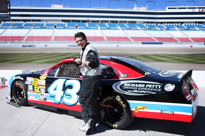 John Katsilometes poses with a race car during the Richard Petty Driving Experience at Las Vegas Motor Speedway on Friday, March 1, 2013.