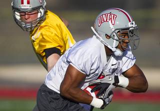 Quarterback Nick Sherry hands off to running back Adonis Smith during practice at Rebel Park at UNLV Monday, March 4, 2013.