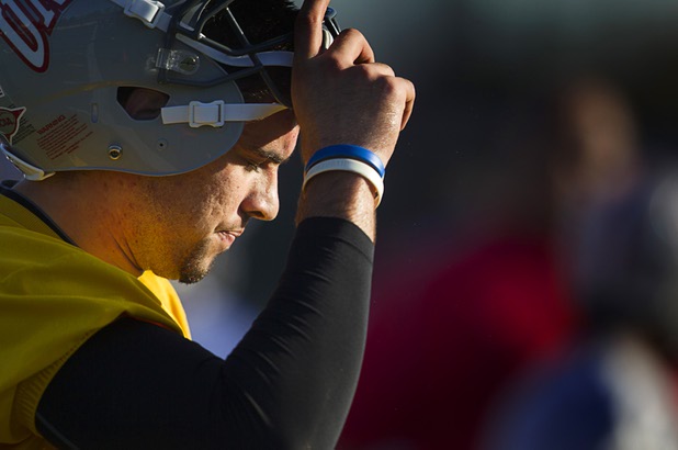 Quarterback Nick Sherry takes off his helmet during a break in practice at Rebel Park at UNLV Monday, March 4, 2013.