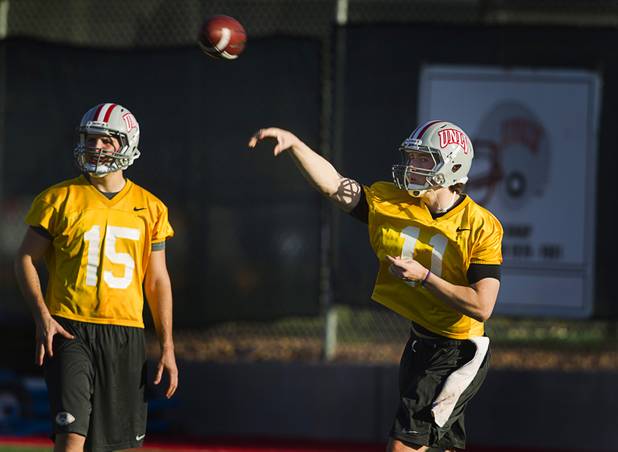 Quarterback Troy Hawthorne, right, passes during practice as quarterback Joe Portaro looks on at Rebel Park at UNLV Monday, March 4, 2013.