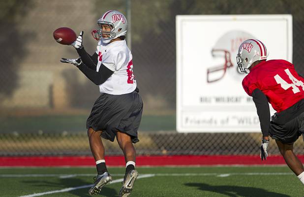 Wide receiver Maika Mataele catches a pass during practice at Rebel Park at UNLV Monday, March 4, 2013. Defensive back Kenny Keys covers at right.