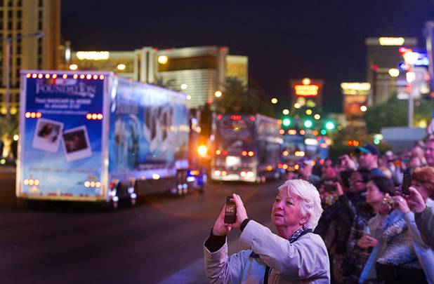 Markie Love, of Peoria, Ill. takes a photo during a parade of NASCAR haulers on the Las Vegas Strip Wednesday, March 6, 2013.  The NASCAR hauler parade traveled north on the Las Vegas Strip to Sahara Avenue, then on I-15 to the Las Vegas Motor Speedway.