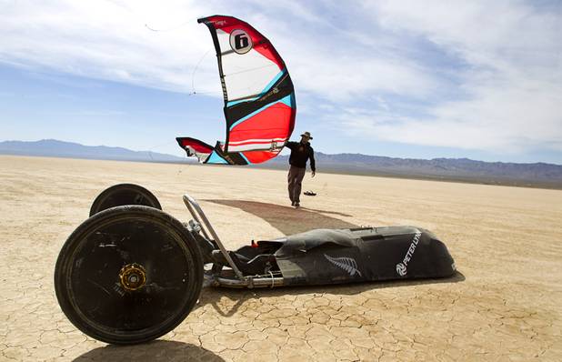 Brian Holgate, 28,  carries a kite to a specially-designed Peter Lynn kite buggy on the Ivanpah dry lake bed near Primm, Nev. Wednesday, March 6, 2013. Holgate set an unofficial kite buggy speed record of 84.4 mph at the lake bed in July 2012.