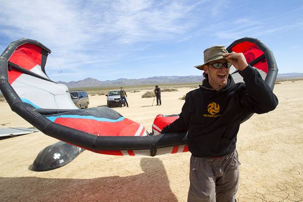 Brian Holgate, 28,  carries a kite to a specially-designed Peter Lynn kite buggy on the Ivanpah dry lake bed near Primm, Nev. Wednesday, March 6, 2013. Holgate set an unofficial kite buggy speed record of 84.4 mph at the lake bed in July 2012.