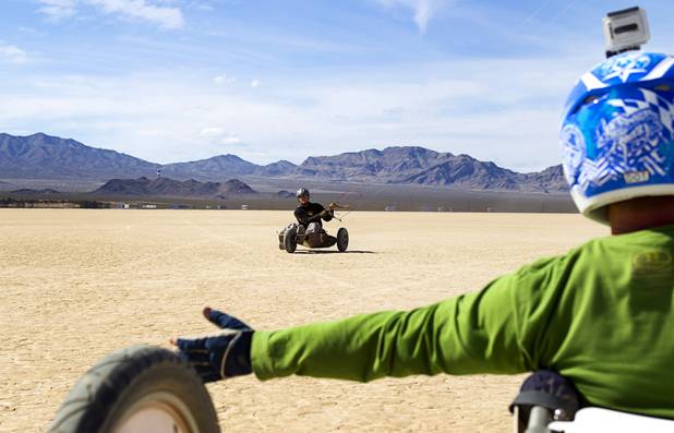 Brian Holgate, left, 28, rides in a free-style kite buggy on the Ivanpah dry lake bed near Primm, Nev. Wednesday, March 6, 2013. Holgate set an unofficial kite buggy speed record of 84.4 mph at the lake bed in July 2012.