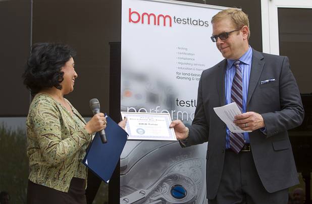 Sonia Joya, representing Nevada Governor Brian Sandoval, presents a certificate of recognition from the governor's office to Mike Dreitzer, COO of BMM Americas, during the opening of the BMM Testlabs new world headquarters in Las Vegas Thursday, March 7, 2013. BMM employs more than 200 people in 12 countries and operates 11 gaming labs, serving more than 400 gaming jurisdictions.