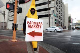 Walter Thomas, Jr. promotes the downtown farmer's market during a rainy day in Las Vegas on Friday, March 8, 2013.