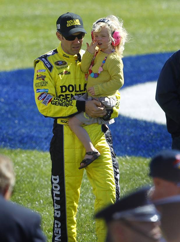 Diver Matt Kenseth carries his daughter Kaylin Nicola as he arrives for driver introductions during the Kobalt Tools 400 NASCAR race at the Las Vegas Motor Speedway Sunday, March 10, 2013. Kenseth won the race.