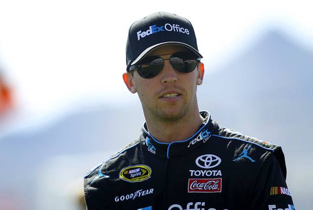 Driver Denny Hamlin (11) walks to a stage for driver introductions during the Kobalt Tools 400 NASCAR race at the Las Vegas Motor Speedway Sunday, March 10, 2013.